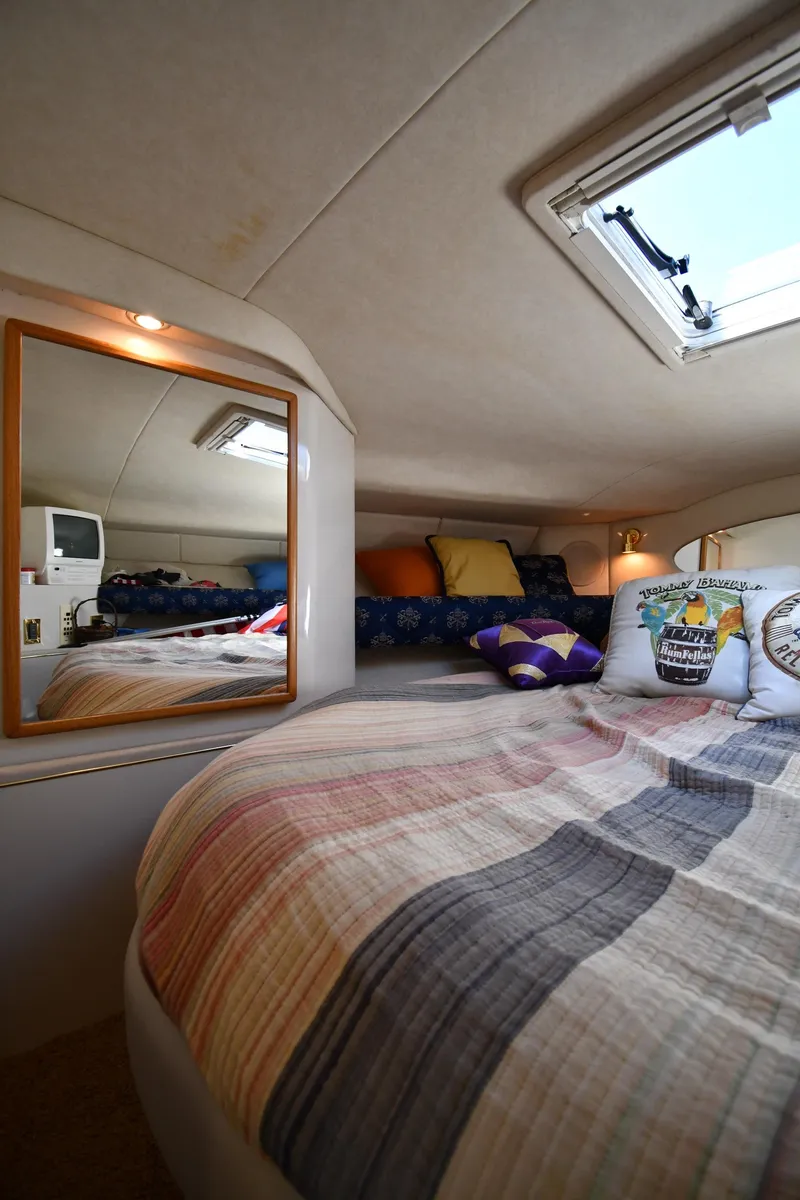 Slide: The Image of Cozy cabin interior of 1997 Sea Ray 400 Sundancer with bed, mirror, and skylight. - 32