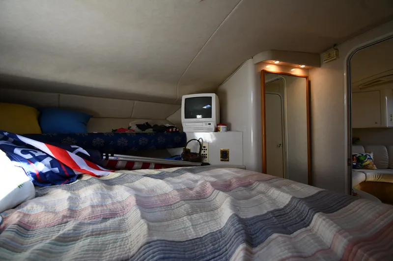 Slide: The Image of Interior cabin of 1997 Sea Ray 400 Sundancer with bed, TV, and cozy decor. - 34