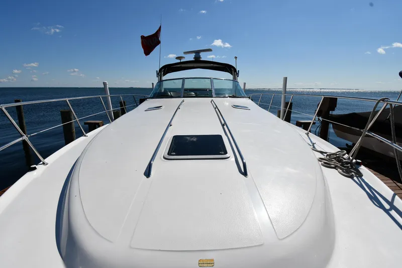 Slide: The Image of 1997 Sea Ray 400 Sundancer yacht on water, clear sky, docked at marina. - 4