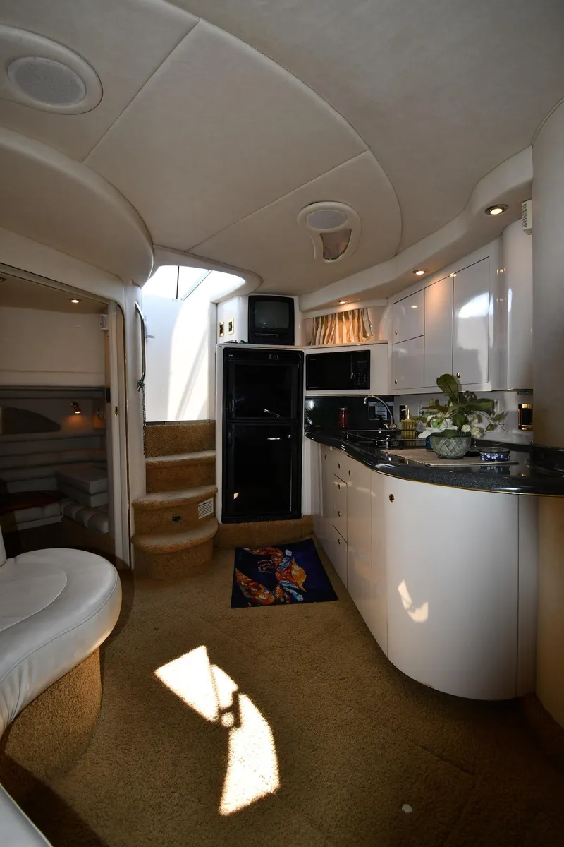 Slide: The Image of Interior of 1997 Sea Ray 400 Sundancer yacht with modern kitchen and cozy seating area. - 44
