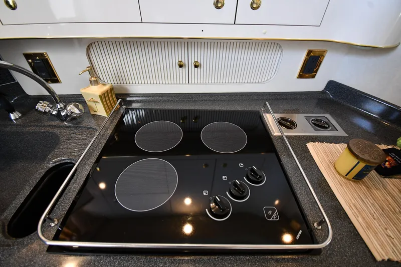 Slide: The Image of Modern kitchen stove in 1997 Sea Ray 400 Sundancer yacht, featuring sleek black cooktop design. - 49
