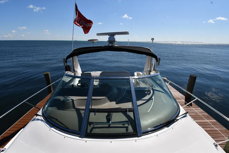 Slide: The Image of 1997 Sea Ray 400 Sundancer docked, with clear skies and calm waters in the background. - 6
