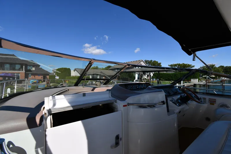 Slide: The Image of 1997 Sea Ray 400 Sundancer cockpit with clear sky and waterfront view. - 9