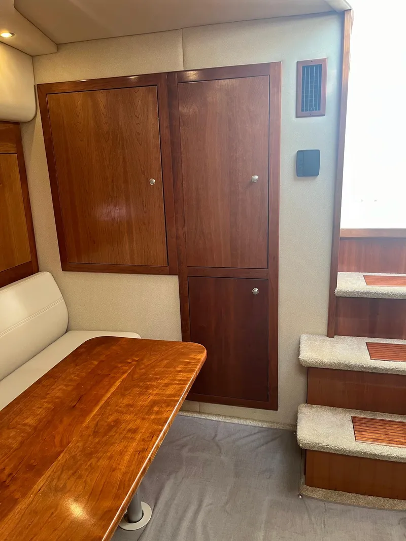 Slide: The Image of 2003 Cruisers Yachts 400 Express interior with wooden cabinets and stairs. - 10