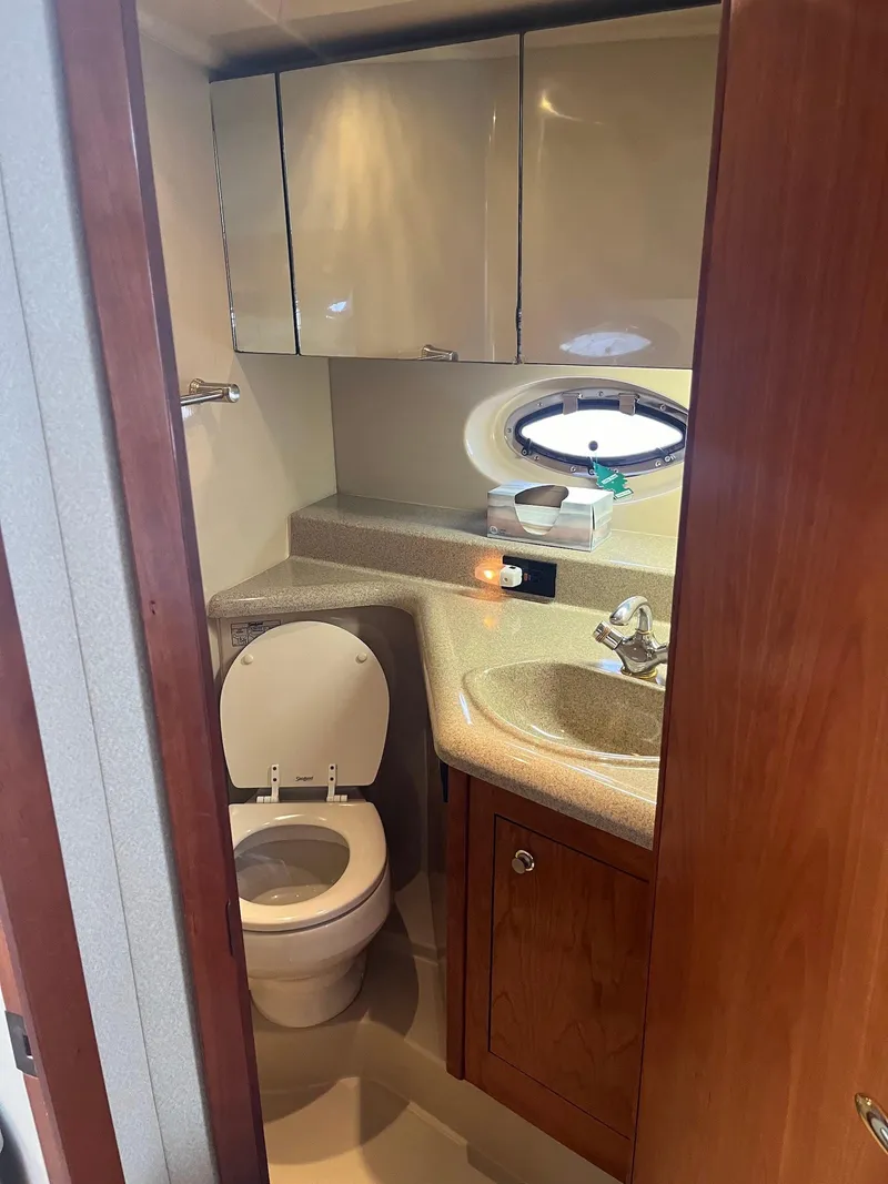 Slide: The Image of 2003 Cruisers Yachts 400 Express bathroom with sink, toilet, and storage cabinets. - 16