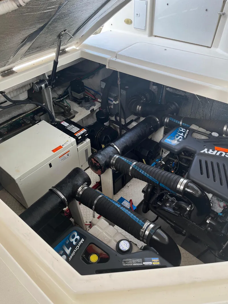 Slide: The Image of Engine compartment of 2003 Cruisers Yachts 400 Express, showcasing dual Mercury engines. - 19