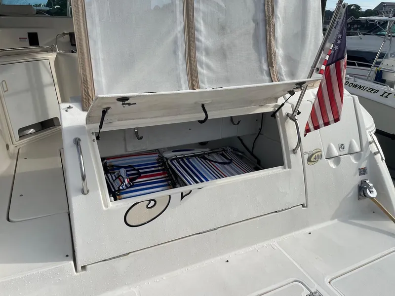 Slide: The Image of 2003 Cruisers Yachts 400 Express with open storage compartment and American flag. - 4