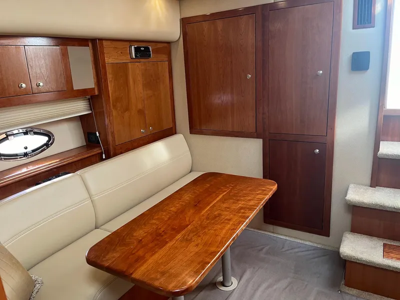 Slide: The Image of Interior of 2003 Cruisers Yachts 400 Express with wooden cabinetry and beige seating. - 9