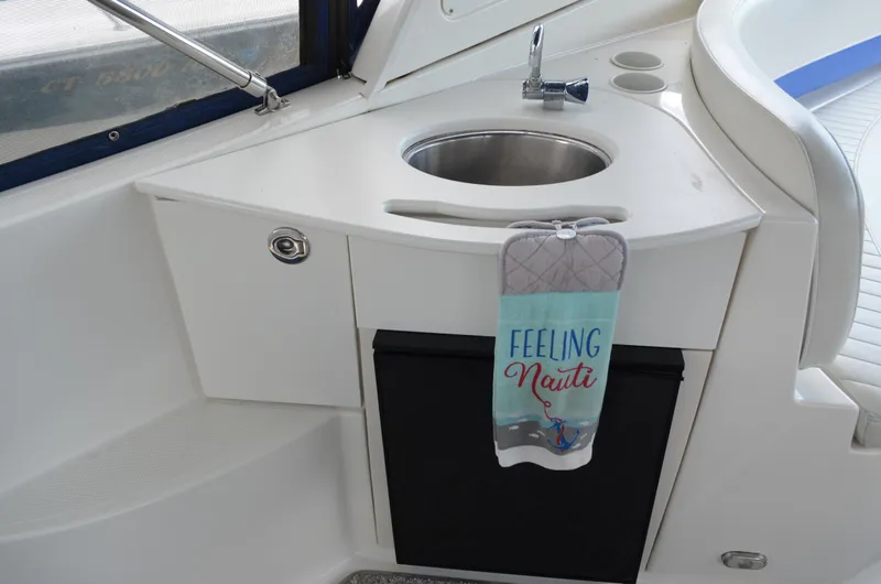 Slide: The Image of 2007 Bayliner 325 Sunbridge boat sink area with "Feeling Nauti" towel. - 11