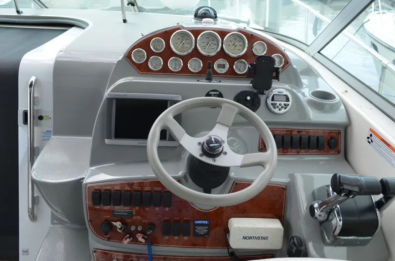 Slide: The Image of 2007 Bayliner 325 Sunbridge helm with steering wheel, gauges, and navigation controls. - 20