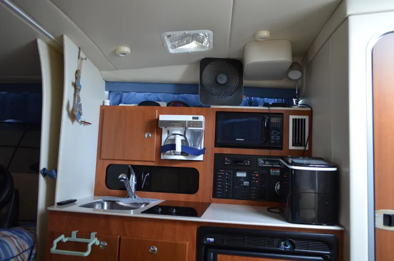 Slide: The Image of 2007 Bayliner 325 Sunbridge interior kitchen with appliances and wooden cabinetry. - 30