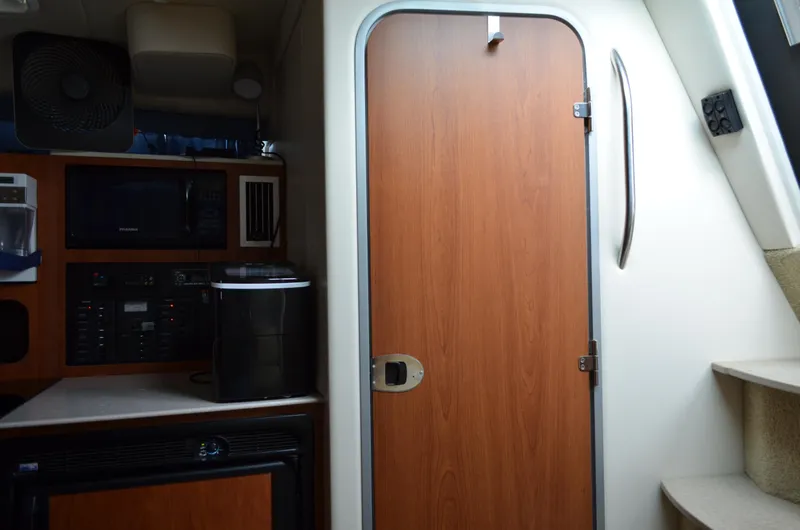 Slide: The Image of Interior of 2007 Bayliner 325 Sunbridge with wooden door and kitchenette area. - 32