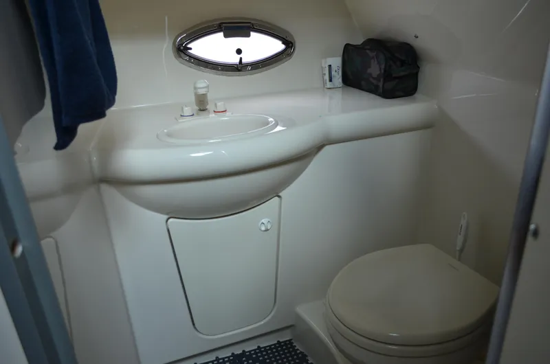 Slide: The Image of 2007 Bayliner 325 Sunbridge bathroom with sink, toilet, and porthole window. - 33