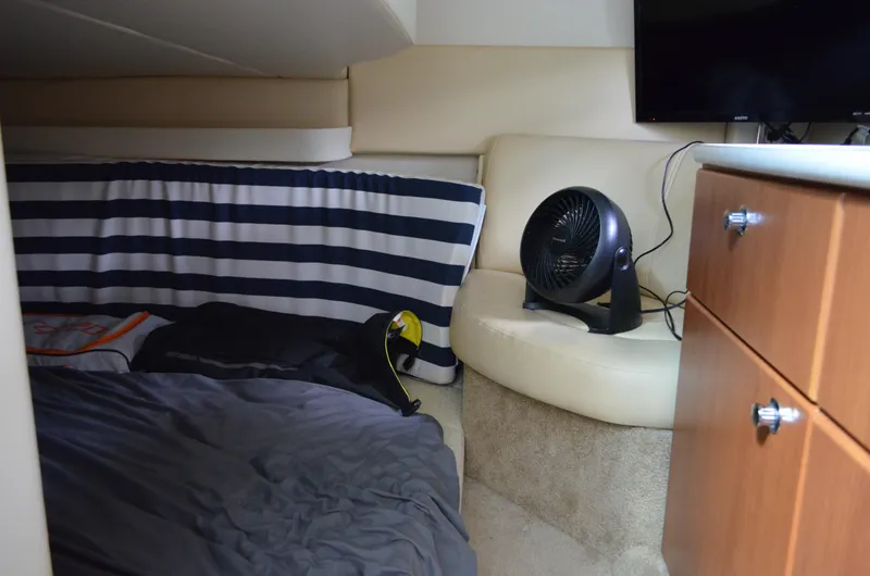 Slide: The Image of Cozy cabin interior of 2007 Bayliner 325 Sunbridge with striped bedding and fan. - 36