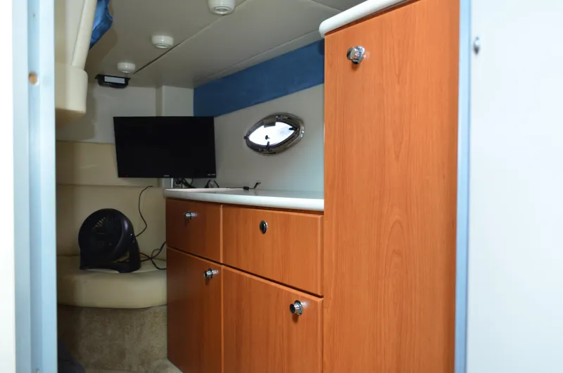 Slide: The Image of 2007 Bayliner 325 Sunbridge cabin interior with wood cabinetry and TV. - 37