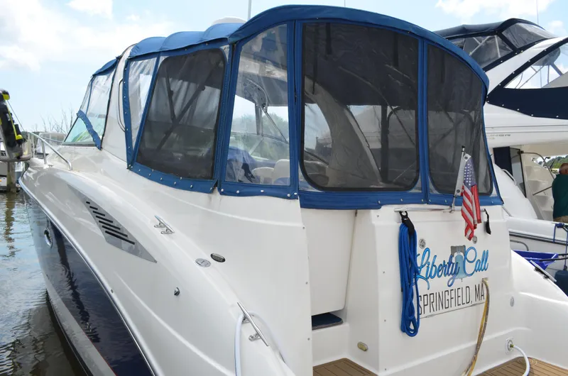 Slide: The Image of 2007 Bayliner 325 Sunbridge boat with blue canopy, docked, displaying "Liberty Call" and American flag. - 5