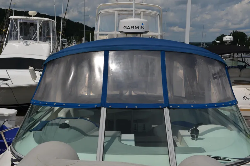 Slide: The Image of 2007 Bayliner 325 Sunbridge boat with blue canopy docked at marina. - 7