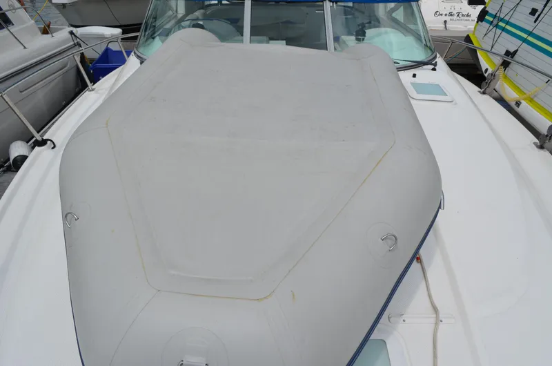 Slide: The Image of 2007 Bayliner 325 Sunbridge boat deck with cover, docked among other vessels. - 8