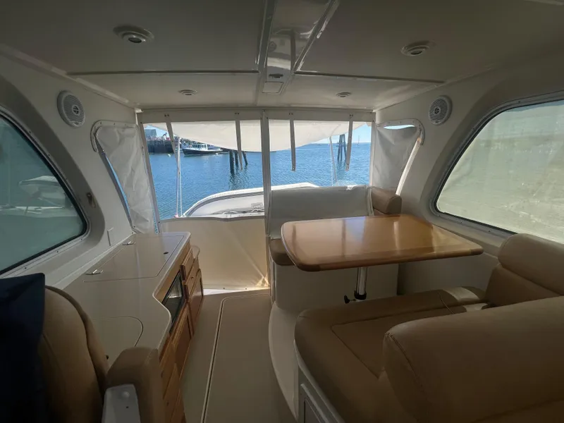 Slide: The Image of Interior of a 2007 Back Cove 33 boat with beige seating and a wooden table. - 18