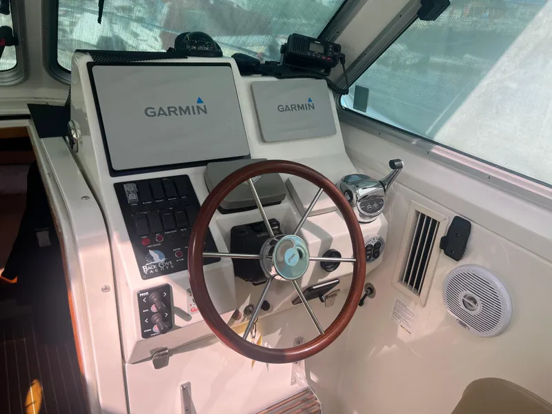 Slide: The Image of 2007 Back Cove 33 boat docked, blue hull, white cabin, moored with red ropes and blue fenders. - 5