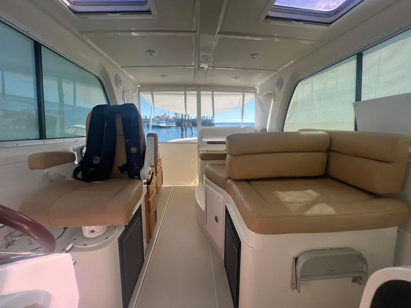 Slide: The Image of 2007 Back Cove 33 interior with beige seating, wooden cabinetry, and nautical decor. - 8
