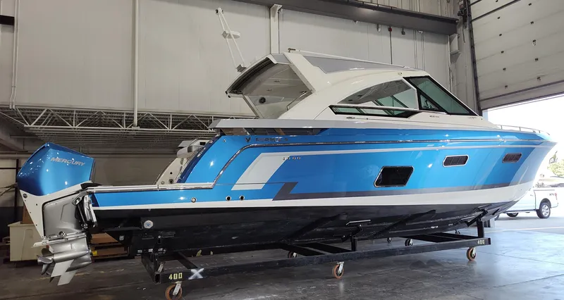 Slide: The Image of 2019 Formula 400 Super Sport Crossover boat in a warehouse, featuring a sleek blue and white design. - 2