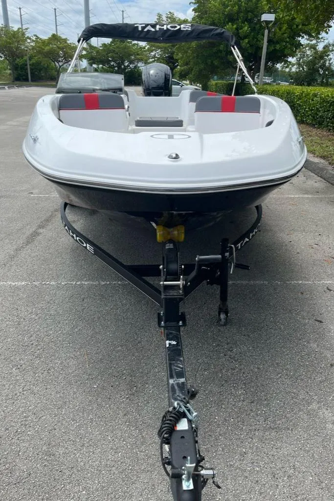 Slide: The Image of 2024 Tahoe T16 boat on trailer, parked outdoors. - 2
