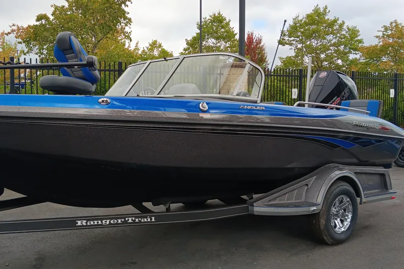 The Image of 2024 Ranger 1880MS boat on trailer, blue and black design, parked outdoors. - 0