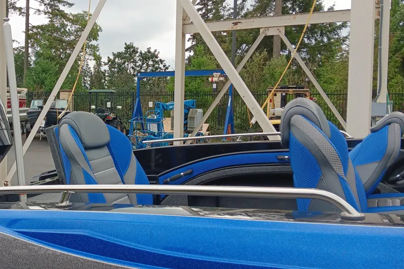Slide: The Image of 2024 Ranger 1880MS boat with blue and gray seats in a marina setting. - 4
