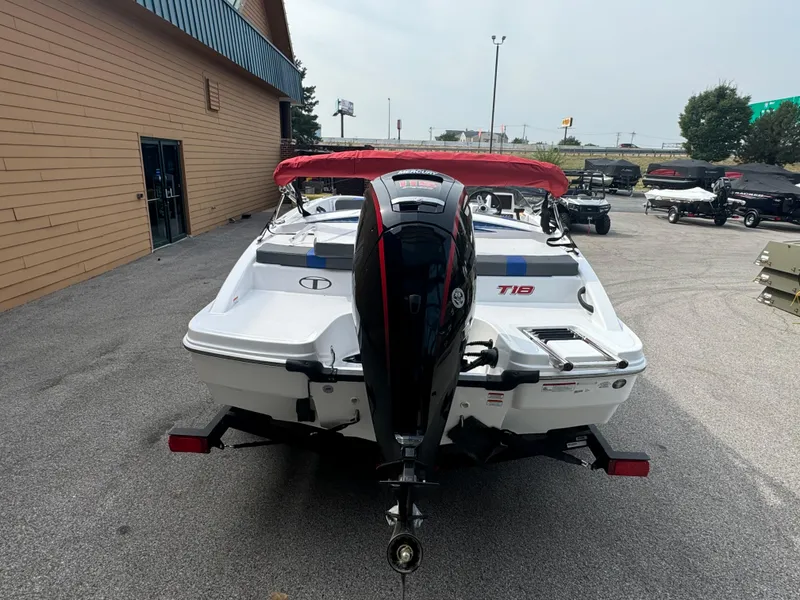 Slide: The Image of 2024 Tahoe T18 boat with red canopy, rear view in outdoor setting. - 2