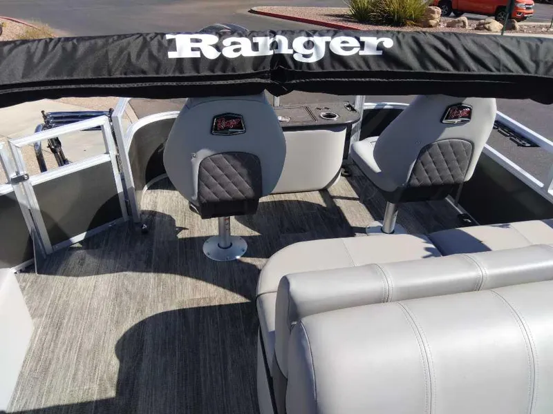 Slide: The Image of 2024 Ranger Reata 220F boat interior with cushioned seating and steering console. - 4