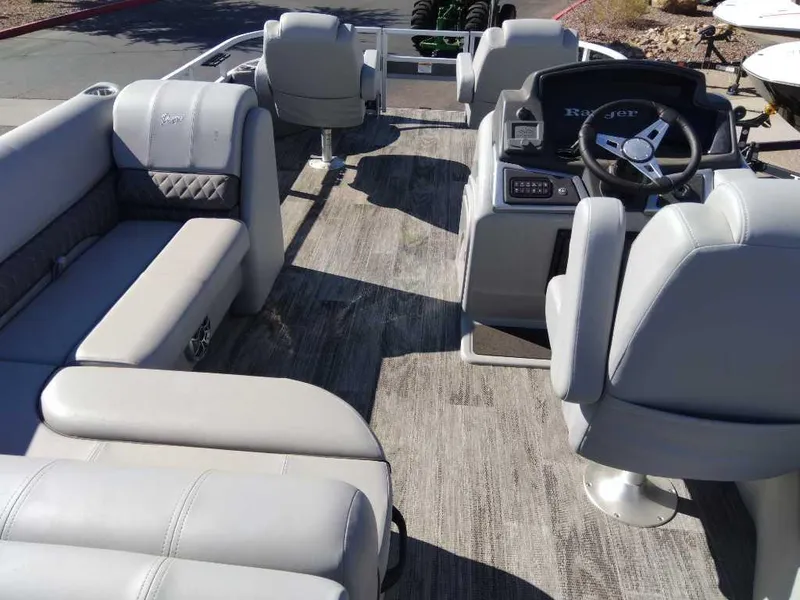 Slide: The Image of 2024 Ranger Reata 220F boat interior with gray seating and steering console. - 5