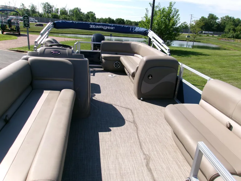 Slide: The Image of 2024 Ranger Reata 200C pontoon boat with spacious seating and scenic outdoor view. - 2
