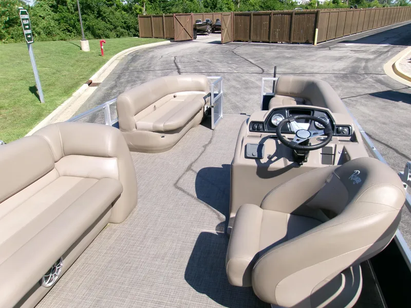 Slide: The Image of 2024 Ranger Reata 200C pontoon boat interior with beige seating and steering console. - 3