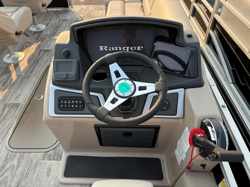 Slide: The Image of 2024 Ranger Reata 223FC boat console with steering wheel and controls. - 6