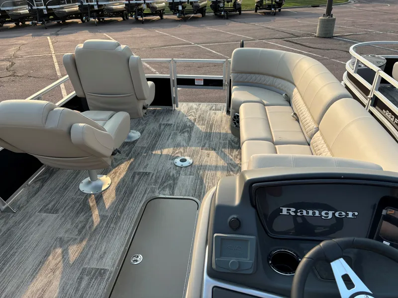 Slide: The Image of 2024 Ranger Reata 223FC boat interior with plush seating and modern dashboard. - 7