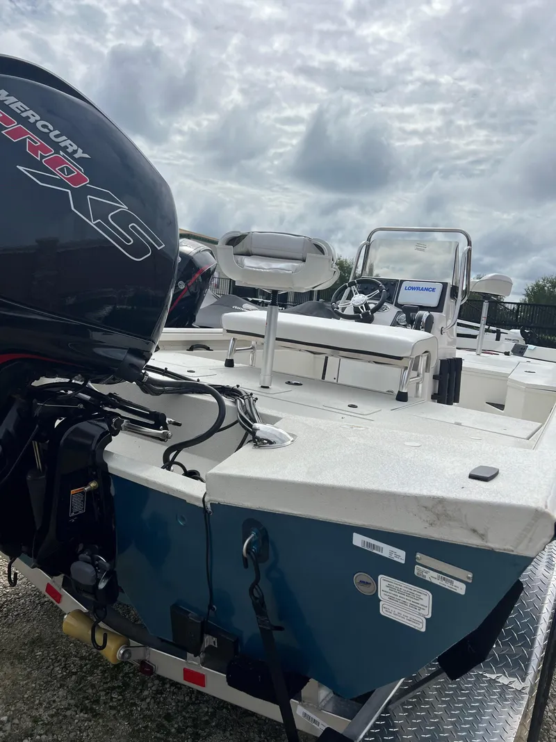 Slide: The Image of 2024 Ranger RB200 boat with Mercury engine, parked on a trailer under cloudy skies. - 2