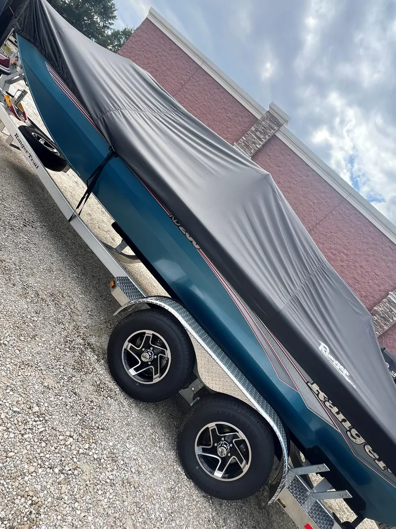Slide: The Image of 2024 Ranger RB200 boat covered on trailer, parked outdoors. - 7