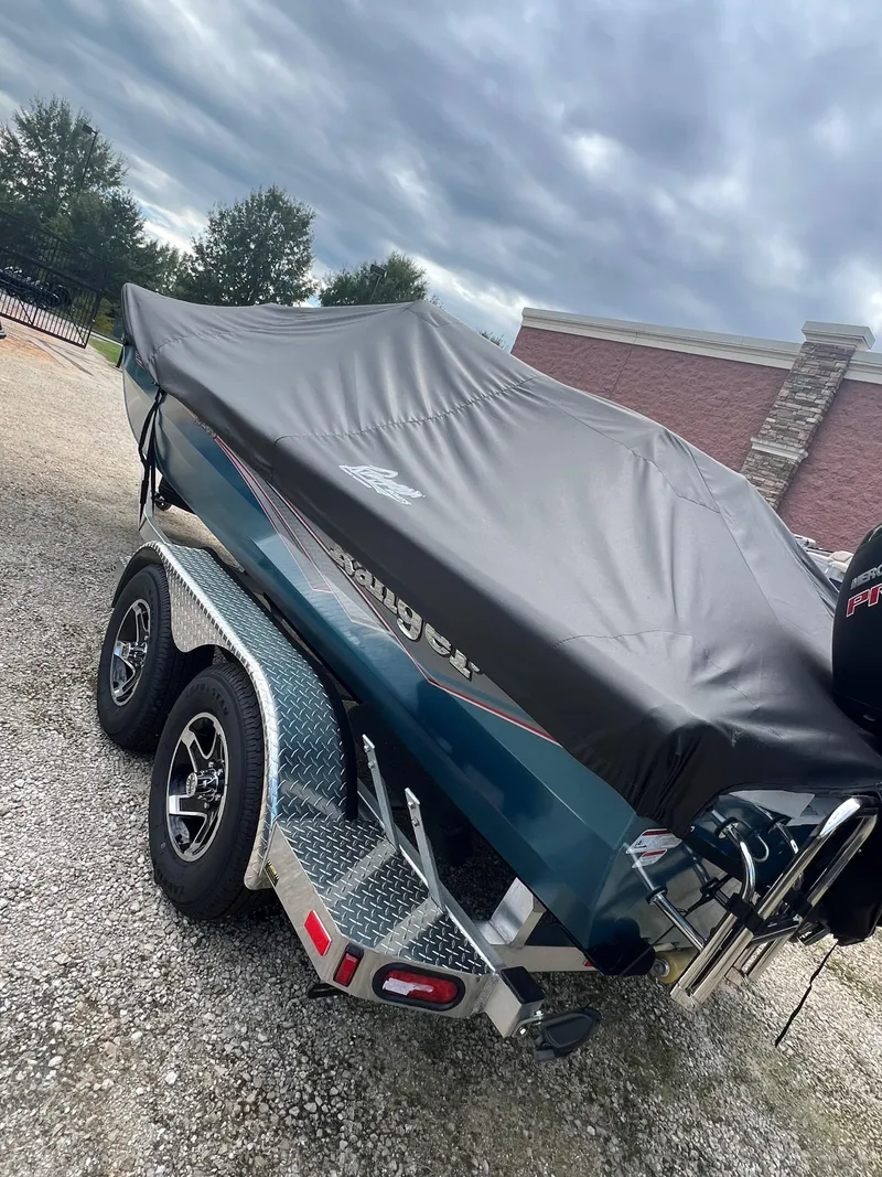 Slide: The Image of 2024 Ranger RB200 boat with cover on trailer, parked outdoors. - 8