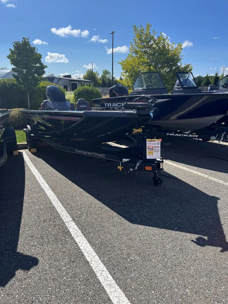 Slide: The Image of 2024 Ranger RT188 boat parked outdoors on a sunny day. - 0