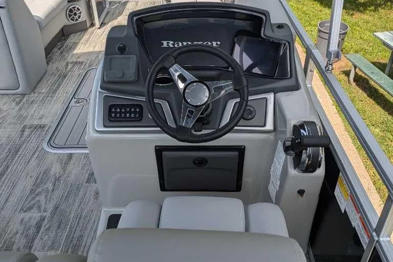 Slide: The Image of 2024 Ranger Reata 223C boat dashboard with steering wheel and controls. - 2
