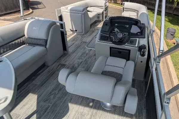 Slide: The Image of 2024 Ranger Reata 223C pontoon boat interior with modern seating and steering console. - 3