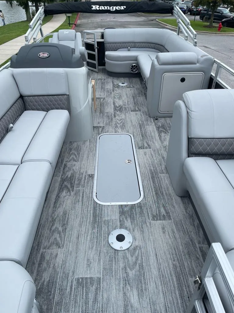Slide: The Image of 2024 Ranger Reata 223C pontoon boat with spacious gray seating and modern flooring. - 3