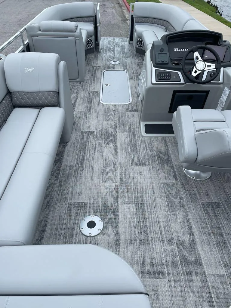 Slide: The Image of 2024 Ranger Reata 223C boat interior with gray seating and wood-patterned flooring. - 4