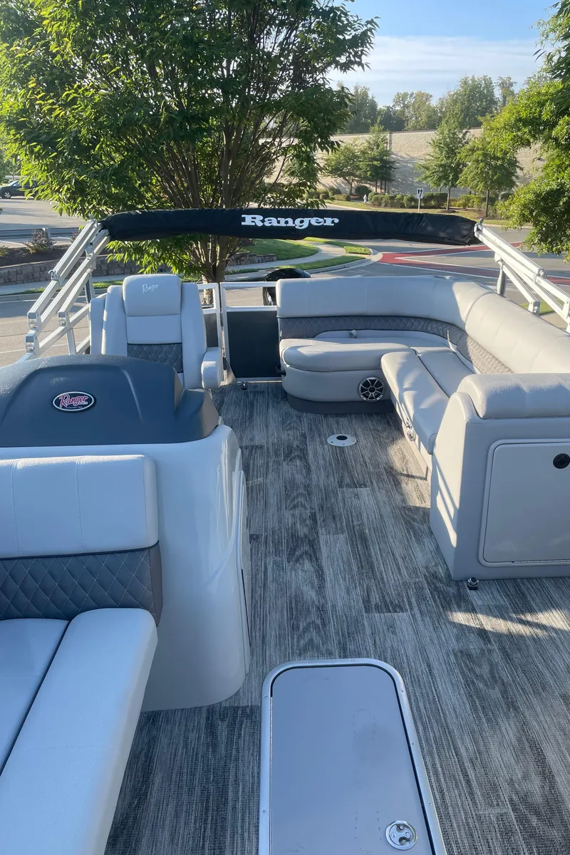 Slide: The Image of 2024 Ranger Reata 223C pontoon boat interior with seating and helm. - 3