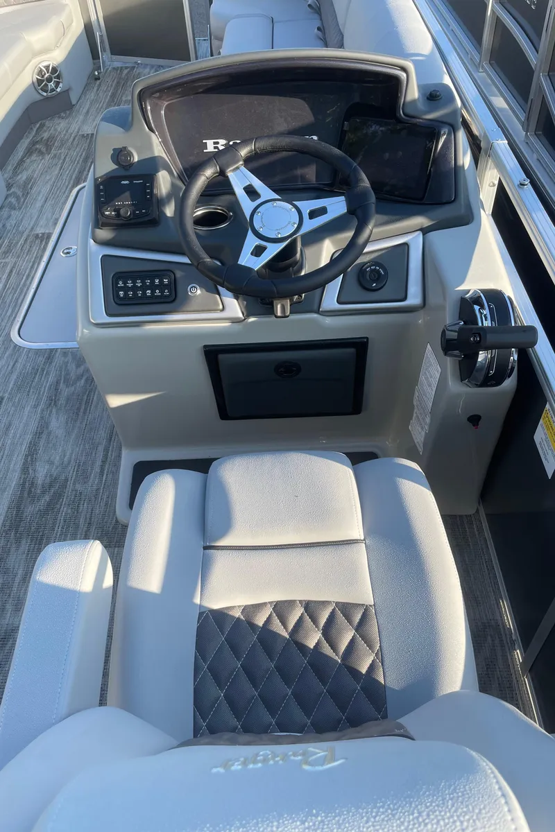 Slide: The Image of 2024 Ranger Reata 223C boat interior with steering wheel and control panel. - 5