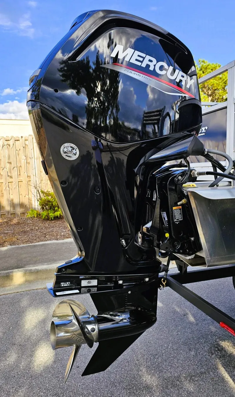 Slide: The Image of 2024 Ranger Reata 200F boat with Mercury outboard motor, parked outdoors. - 5