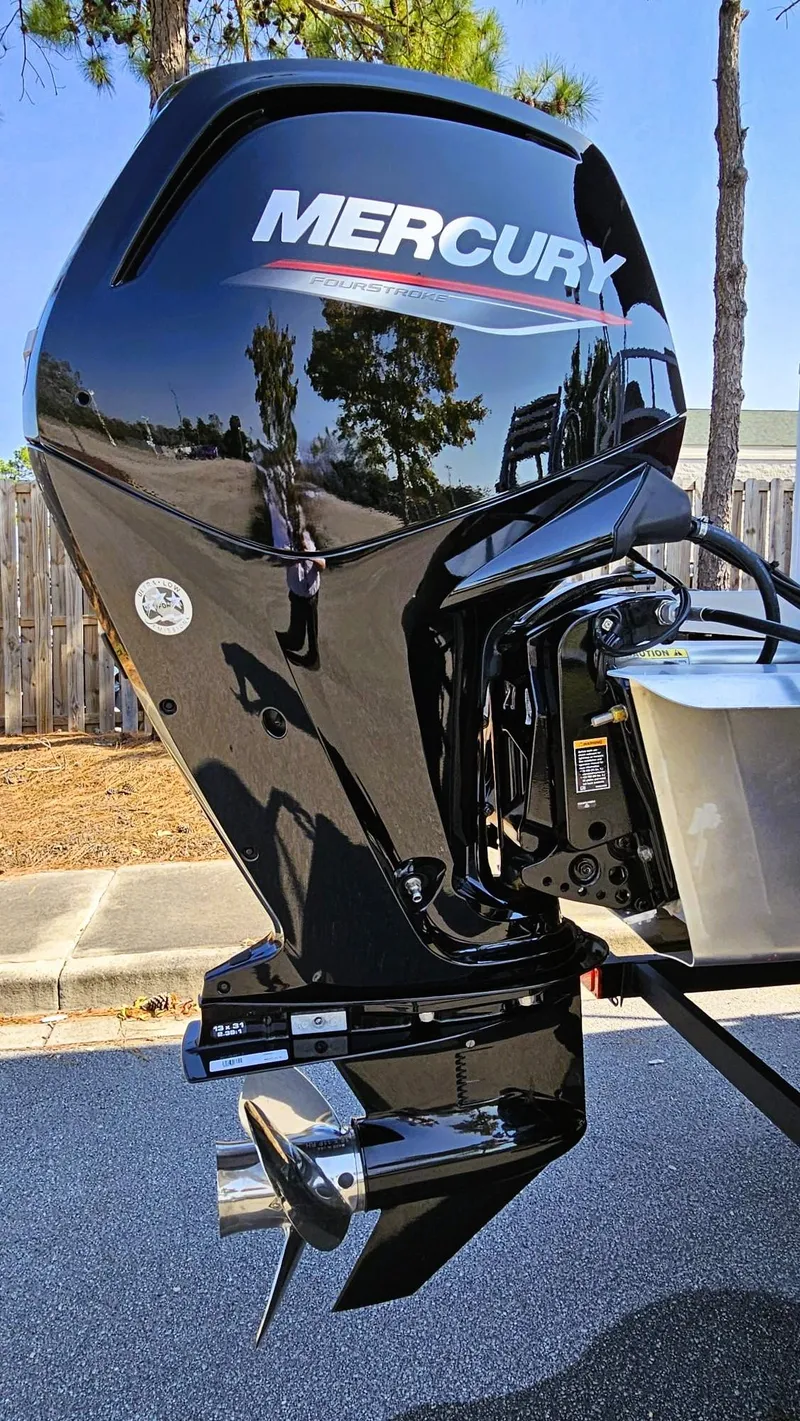 Slide: The Image of 2024 Ranger Reata 200C boat with Mercury outboard motor, parked outdoors. - 5