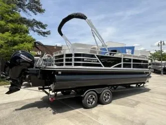 Slide: The Image of 2024 Ranger Reata 223C pontoon boat on trailer, parked outdoors. - 2