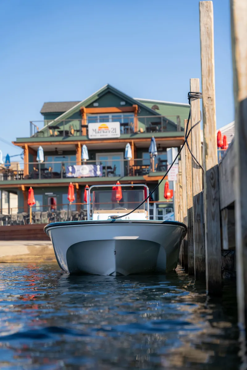 Slide: The Image of 2024 Wolfeboro Classic 15 boat docked near waterfront restaurant. - 6